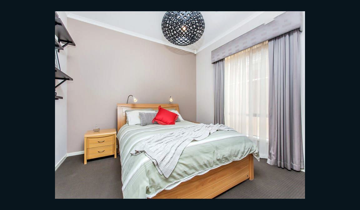 A bedroom at Condamine Street, with a built-in robe and a curtained window