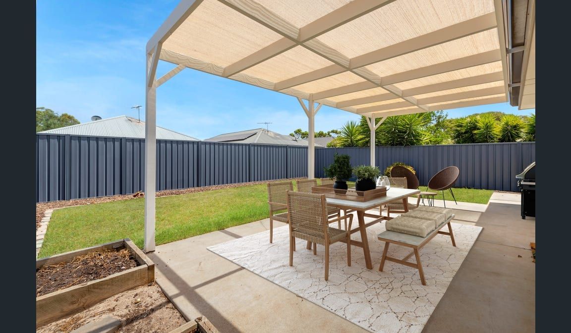 The covered pergola and lawn at the rear of the Peerless Road home